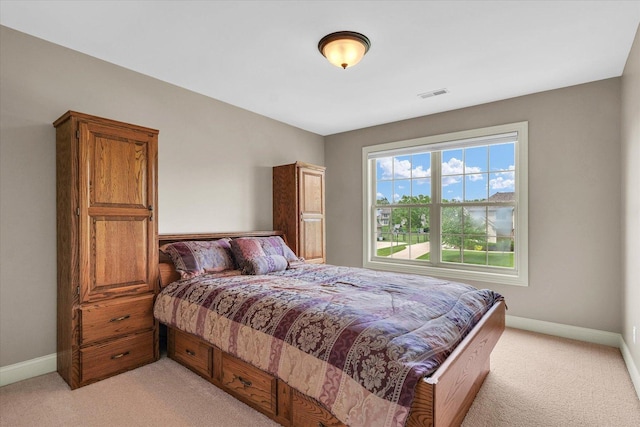 bedroom with light carpet and baseboards
