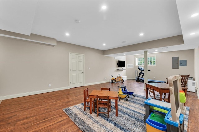 game room featuring wood finished floors, recessed lighting, baseboards, electric panel, and baseboard heating