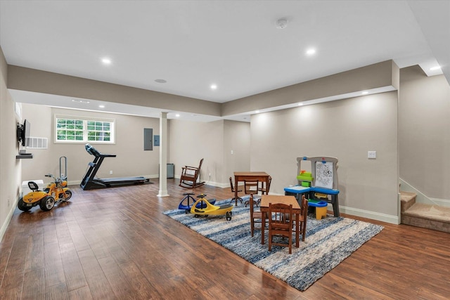 playroom with wood finished floors, baseboards, electric panel, and recessed lighting