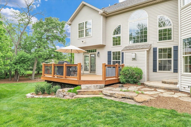 rear view of property with a lawn and a deck