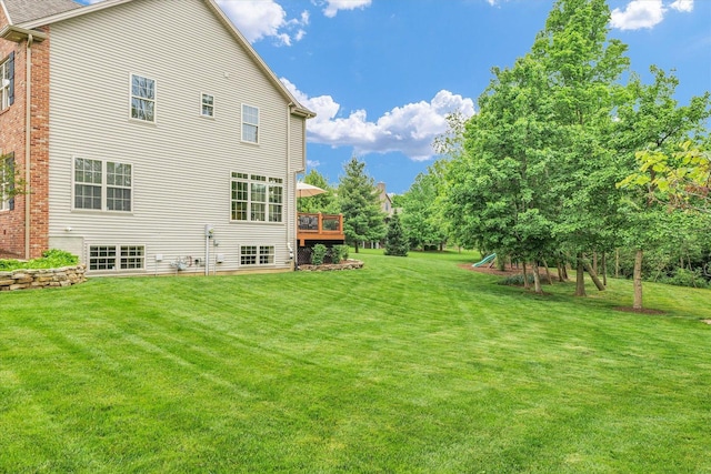 rear view of house with a yard and a wooden deck
