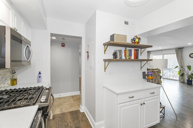900 Center St Unit 2I, Des Plaines, IL 60016 - kitchen with visible vents, appliances with stainless steel finishes, dark wood finished floors, light countertops, and white cabinets