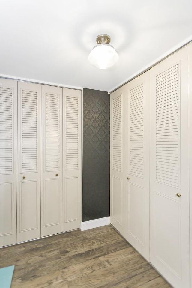 900 Center St Unit 2I, Des Plaines, IL 60016 - unfurnished bedroom featuring baseboards, wallpapered walls, and wood finished floors