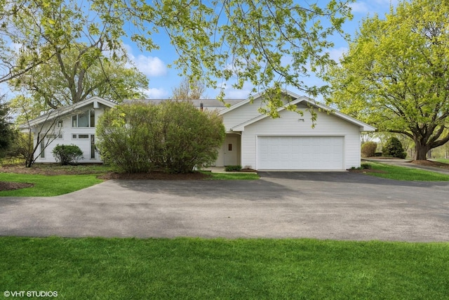 view of front of property featuring a garage, a front yard, and aphalt driveway
