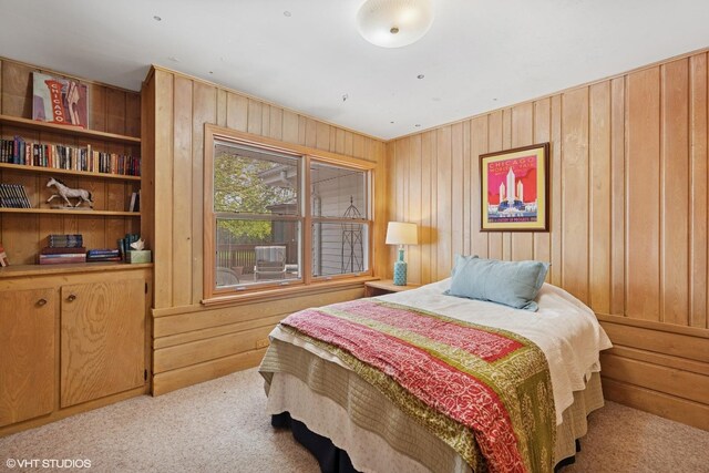 carpeted bedroom featuring wooden walls