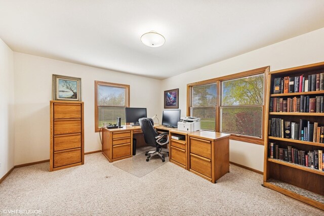 office with baseboards and light carpet