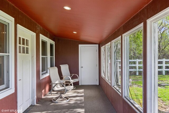 sunroom featuring carpet flooring and vaulted ceiling