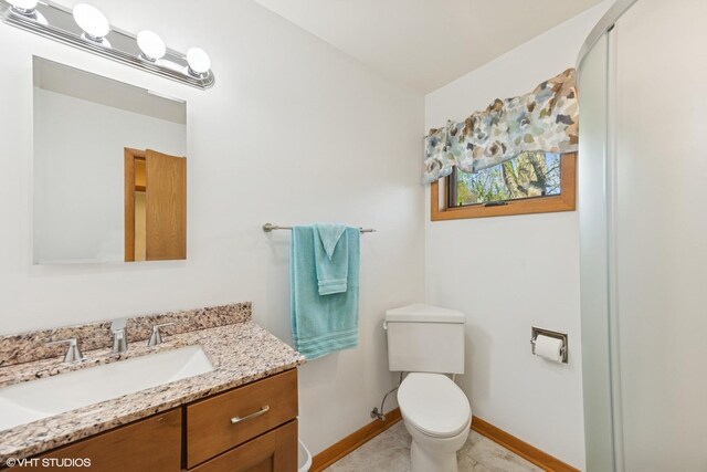 half bath with vanity, baseboards, toilet, and tile patterned flooring