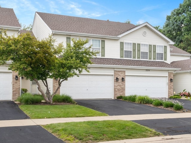 multi unit property featuring brick siding, a shingled roof, and aphalt driveway