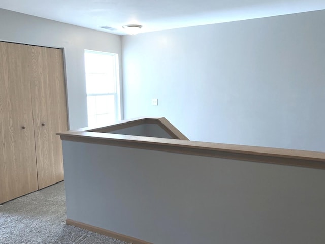 hallway with visible vents and carpet flooring
