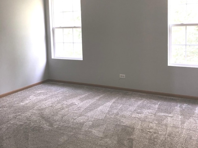 empty room with baseboards and carpet flooring