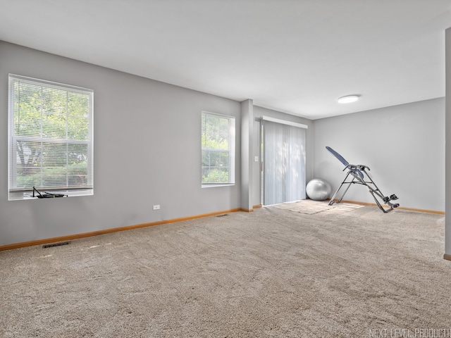 carpeted empty room featuring baseboards and visible vents