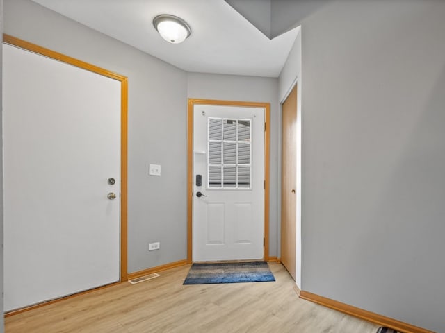entryway with baseboards, light wood-type flooring, and visible vents
