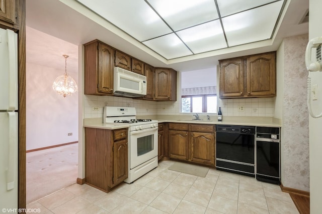 kitchen with white appliances, tasteful backsplash, a sink, and light countertops