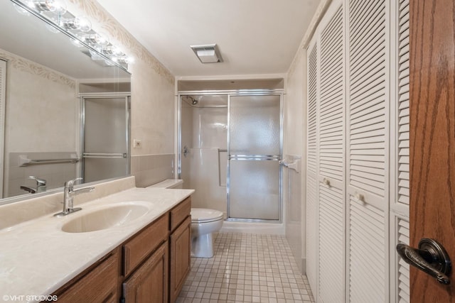full bathroom featuring a closet, a stall shower, visible vents, and vanity