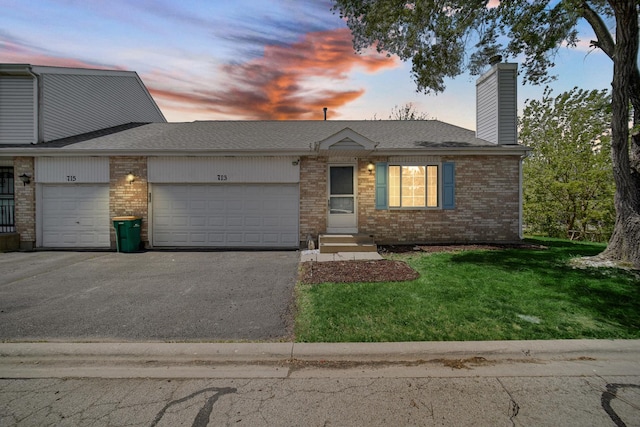 713 Arbury Ct, Romeoville, IL 60446 - view of front of home with an attached garage, a chimney, brick siding, asphalt driveway, and a front yard
