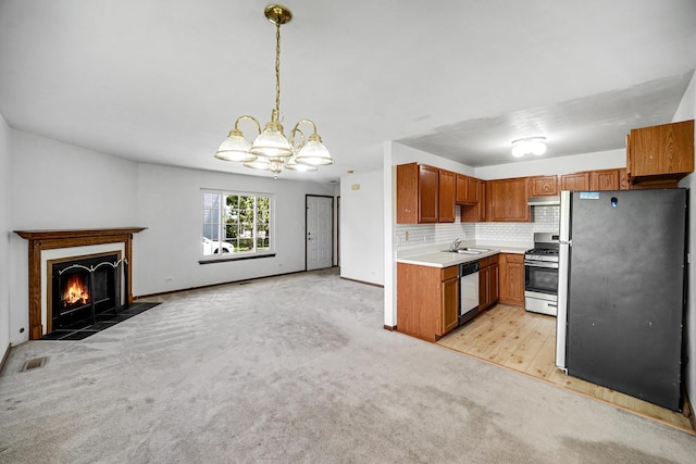 713 Arbury Ct, Romeoville, IL 60446 - kitchen featuring appliances with stainless steel finishes, a sink, a chandelier, light colored carpet, and light countertops