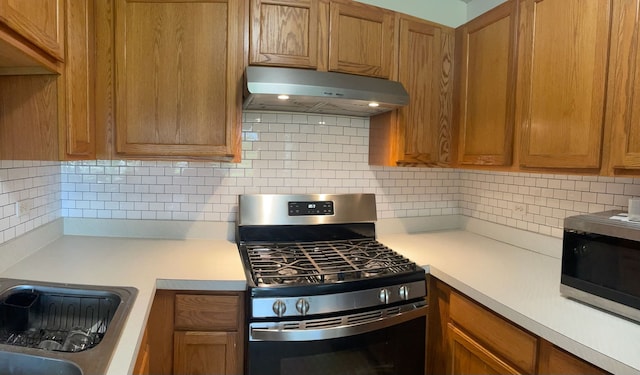 713 Arbury Ct, Romeoville, IL 60446 - kitchen featuring appliances with stainless steel finishes, under cabinet range hood, light countertops, brown cabinets, and tasteful backsplash