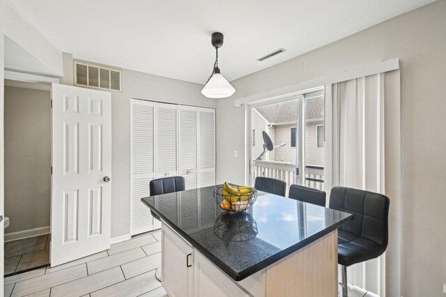 dining room featuring visible vents, baseboards, and wood finish floors