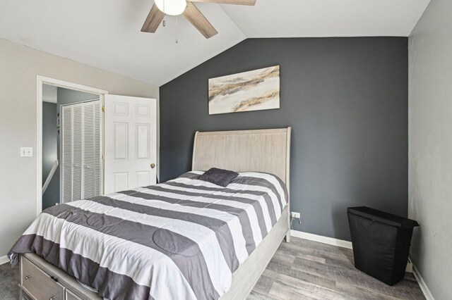 bedroom featuring baseboards, lofted ceiling, wood finished floors, and ceiling fan