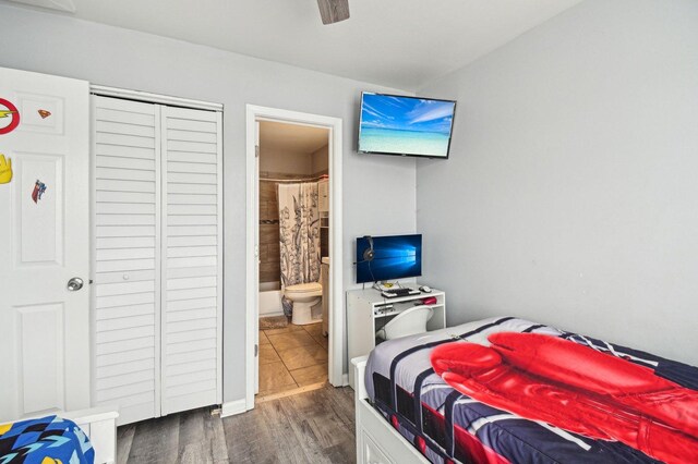 bedroom with dark wood-style flooring, ceiling fan, a closet, and ensuite bath
