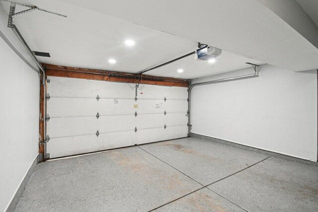 garage featuring recessed lighting, baseboards, and a garage door opener