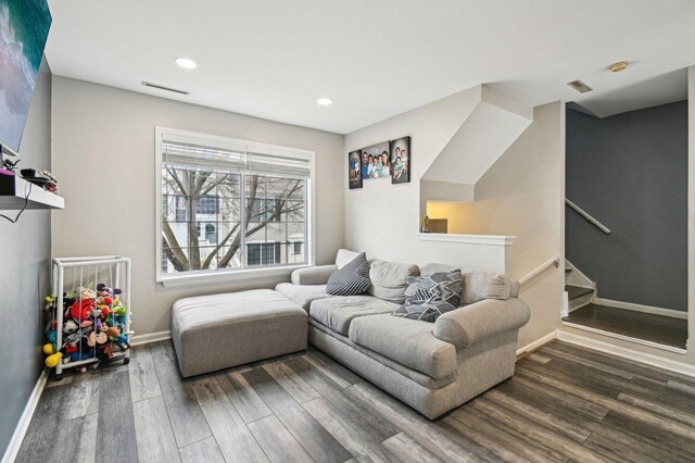 living room with recessed lighting, baseboards, wood finished floors, visible vents, and stairway