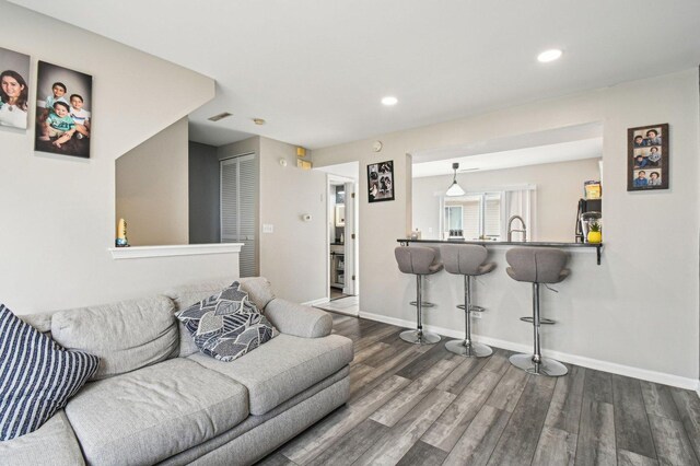 living room featuring recessed lighting, baseboards, and wood finished floors