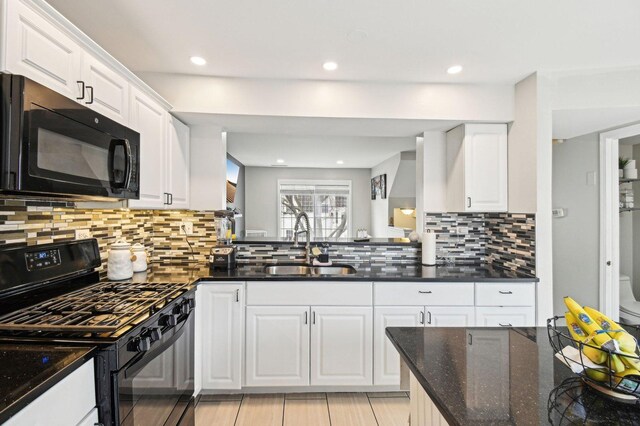 kitchen with a sink, decorative backsplash, white cabinets, and black appliances