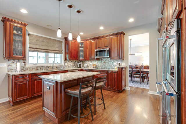 2550 Bayswater Cir, Gurnee, IL 60031 - kitchen with stainless steel microwave, dark wood finished floors, a sink, a center island, and recessed lighting
