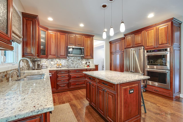 2550 Bayswater Cir, Gurnee, IL 60031 - kitchen with appliances with stainless steel finishes, a sink, tasteful backsplash, light stone counters, and dark wood-style floors