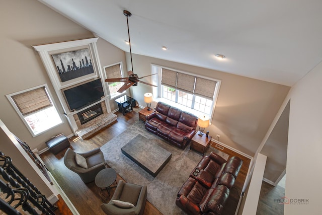 2550 Bayswater Cir, Gurnee, IL 60031 - living area with a ceiling fan, wood finished floors, a glass covered fireplace, vaulted ceiling, and baseboards