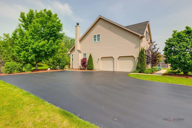 2550 Bayswater Cir, Gurnee, IL 60031 - view of side of property with asphalt driveway, a chimney, and an attached garage
