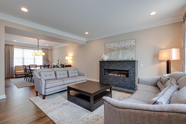 2550 Bayswater Cir, Gurnee, IL 60031 - living room with wood finished floors, a glass covered fireplace, a chandelier, recessed lighting, and crown molding