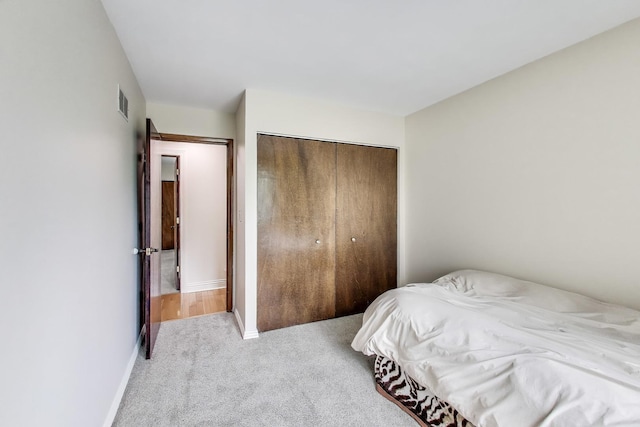 carpeted bedroom with baseboards, a closet, and visible vents