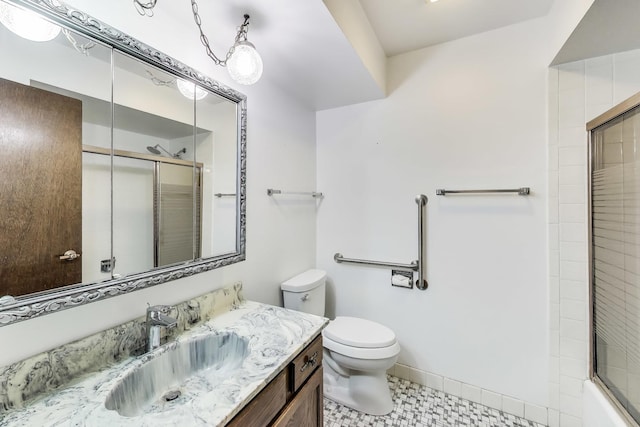 bathroom featuring an enclosed shower, vanity, baseboards, and toilet