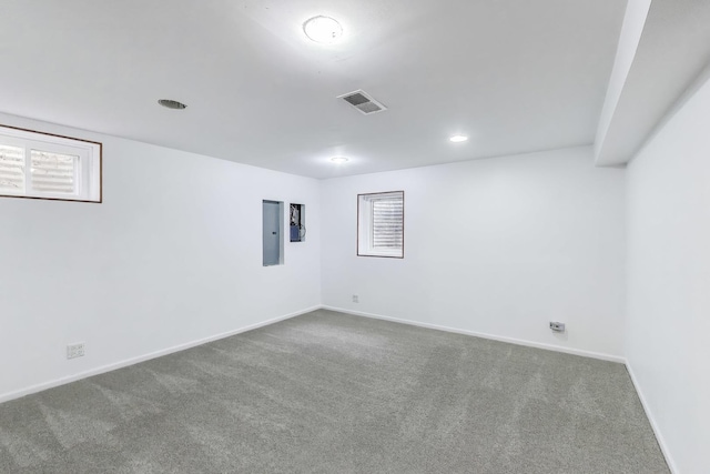 below grade area featuring carpet floors, baseboards, electric panel, and visible vents