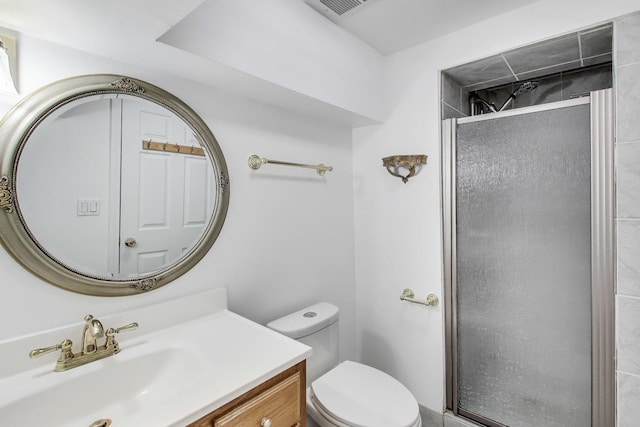 bathroom featuring toilet, visible vents, a shower stall, and vanity