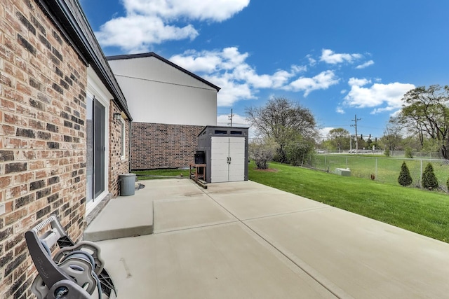 view of patio / terrace with fence, a storage unit, and an outdoor structure