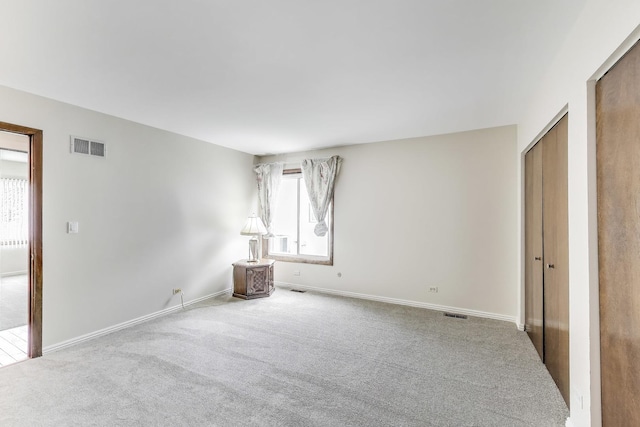 unfurnished bedroom featuring carpet flooring, baseboards, and visible vents