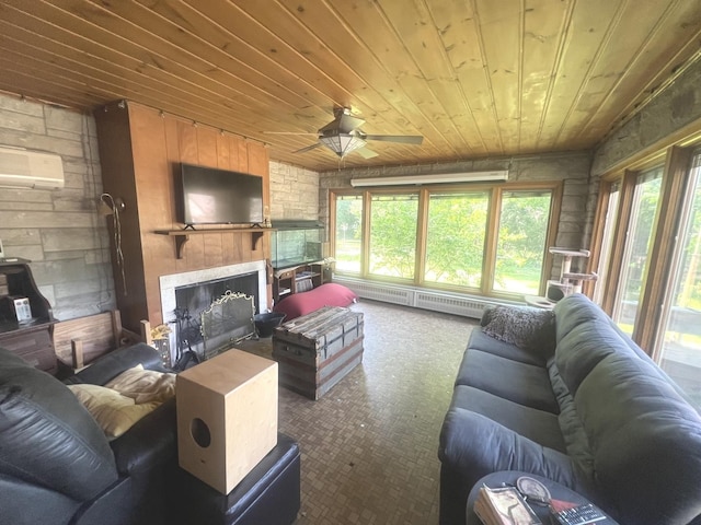 living room with wood ceiling, a baseboard radiator, a large fireplace, a ceiling fan, and carpet flooring