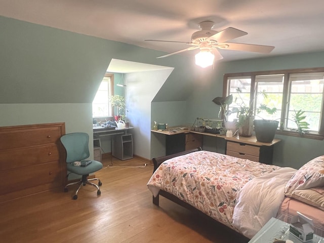 bedroom with light wood-type flooring, an office area, ceiling fan, and lofted ceiling