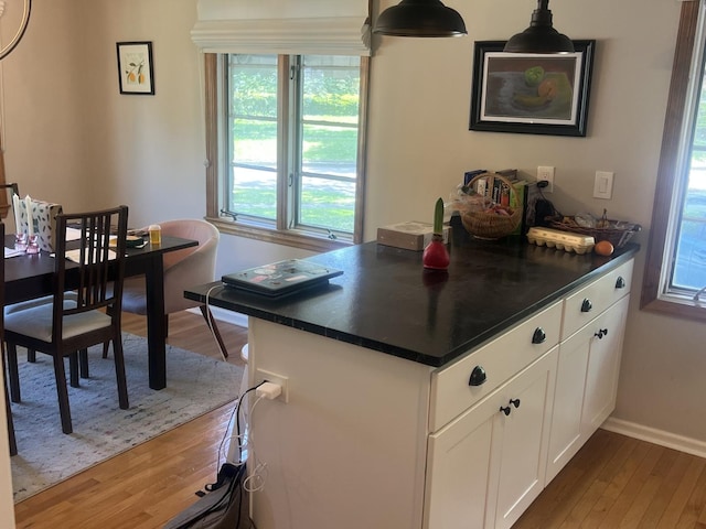 kitchen featuring dark countertops, dark wood finished floors, white cabinets, and baseboards