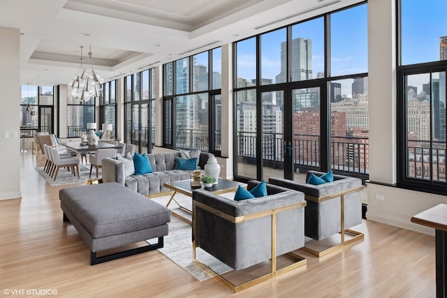 400 W Ontario St Unit 1801, Chicago, IL 60654 - living area featuring a skyline view, light wood finished floors, a wall of windows, a chandelier, and a tray ceiling