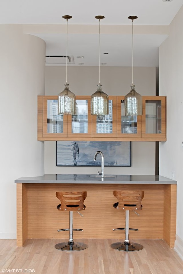 400 W Ontario St Unit 1801, Chicago, IL 60654 - bar featuring a sink, light wood-type flooring, pendant lighting, and baseboards