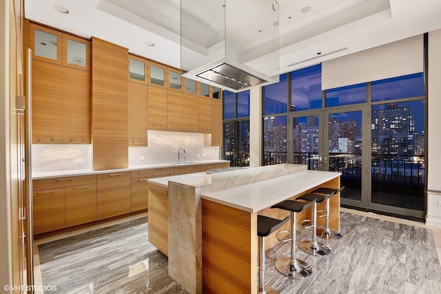 400 W Ontario St Unit 1801, Chicago, IL 60654 - kitchen with a breakfast bar, modern cabinets, a center island, glass insert cabinets, and recessed lighting