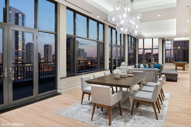 400 W Ontario St Unit 1801, Chicago, IL 60654 - dining area with a skyline view, a raised ceiling, wood finished floors, a chandelier, and a wall of windows
