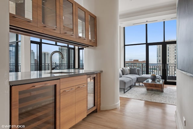400 W Ontario St Unit 1801, Chicago, IL 60654 - bar area with beverage cooler, a sink, a city view, light wood-style floors, and expansive windows