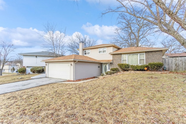 tri-level home with fence, brick siding, a garage, a front yard, and concrete driveway