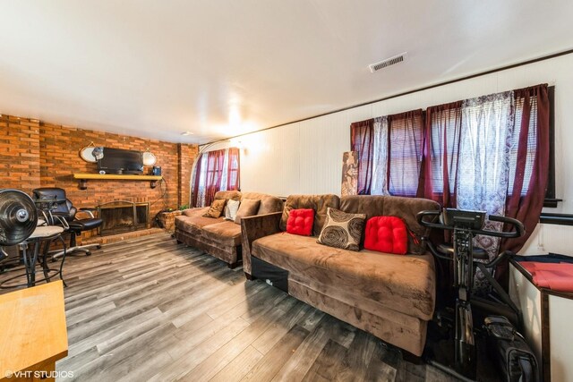 living room with a fireplace, wood finished floors, and visible vents